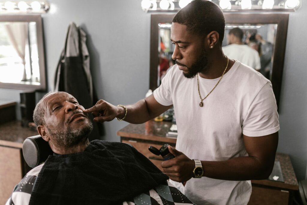 pexels-photo-7697443-7697443 A barber expertly trims an elderly client's beard in a stylish barbershop.